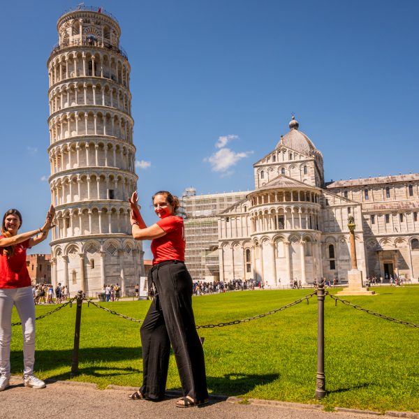 Pisa local guides Anastasia and Andrea playfully pushing the Leaning Tower