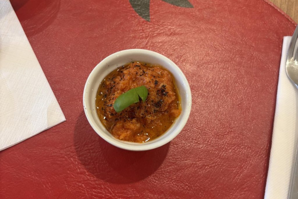 A small pappa al pomodoro topped with a basil leaf